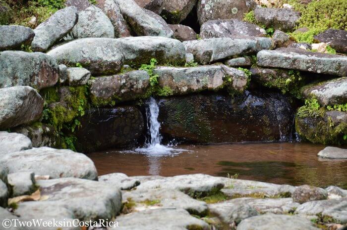 A small stream of water dropping into a stone aqueduct at Guayabo National Monument 