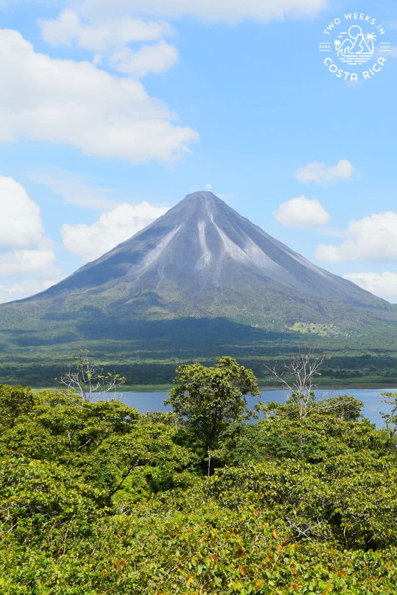 arenal volcano with the lake in front and blue sky