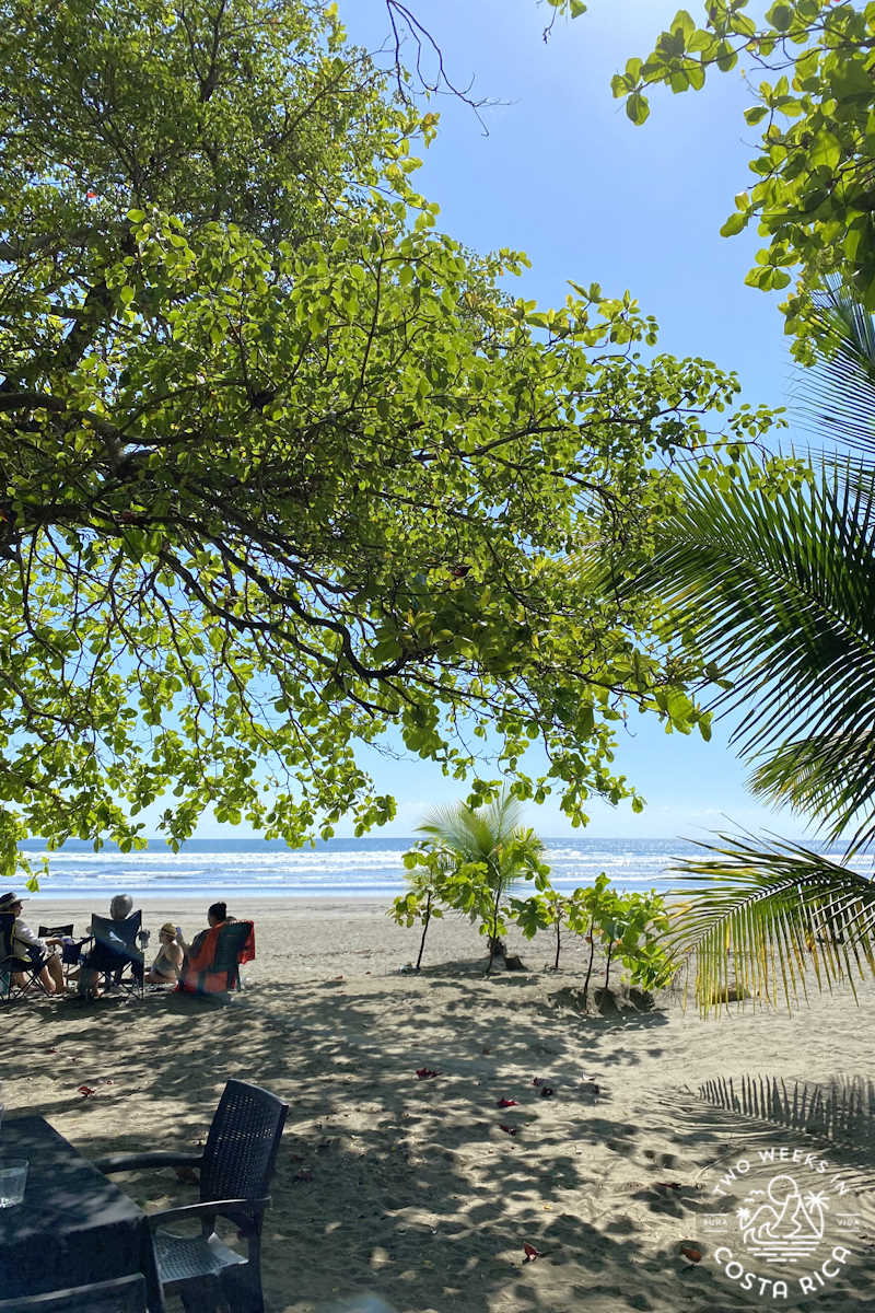 people eating lunch at a table on the beach in esterillos este