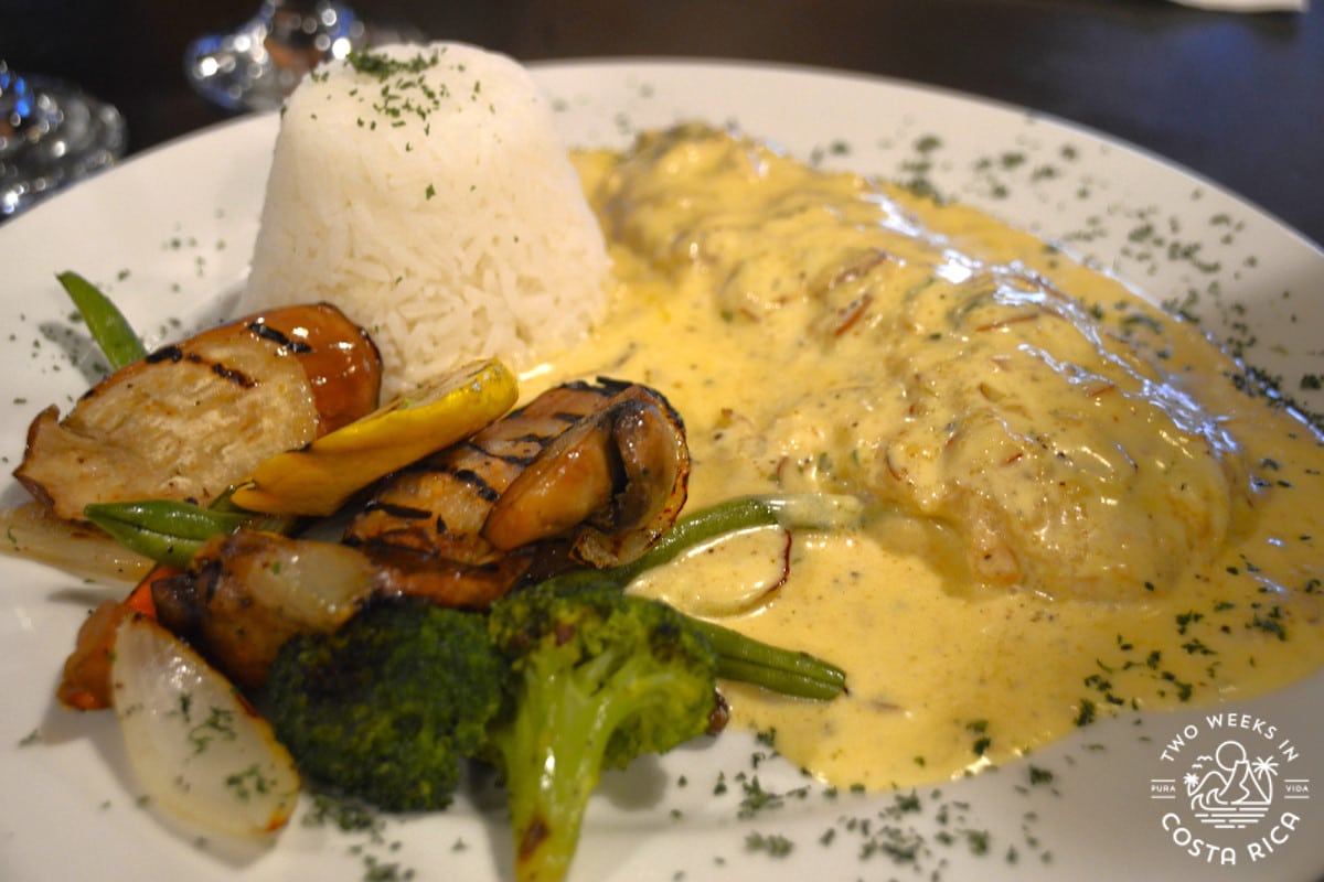 a plate of fish with rice and vegetables