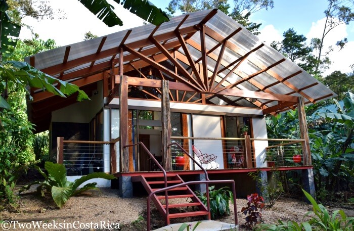 wooden house with a front porch and trees around it 