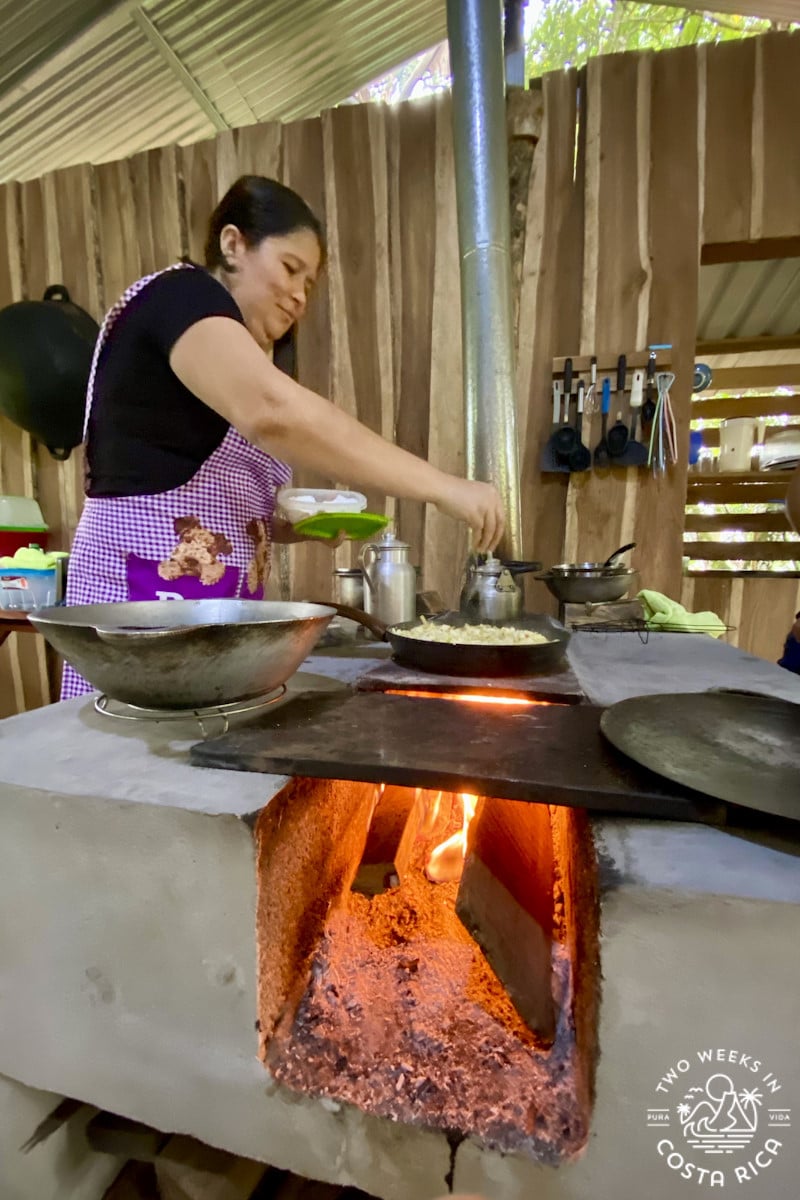woman cooking over a woodstove