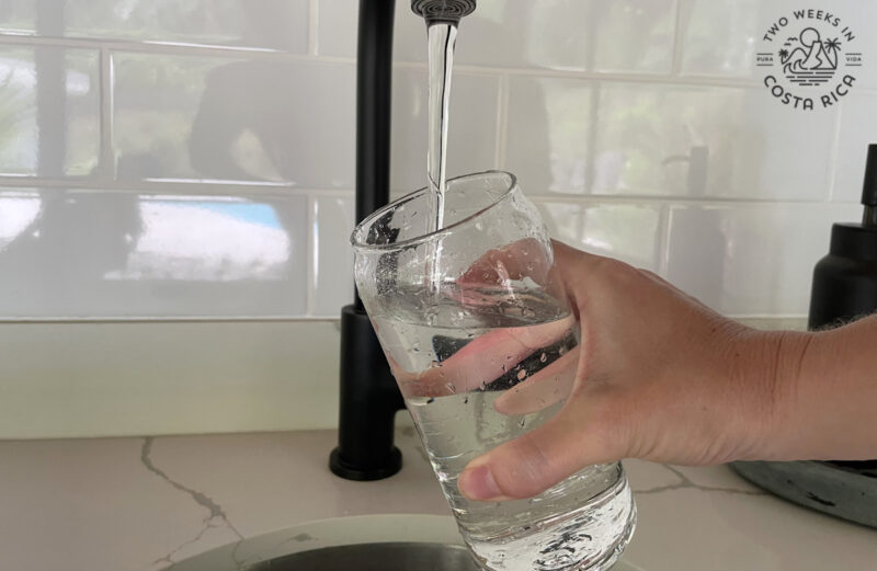 Costa Rica’s Water: Safe to Drink or Buy Bottled? a person filling up a glass of water at the sink