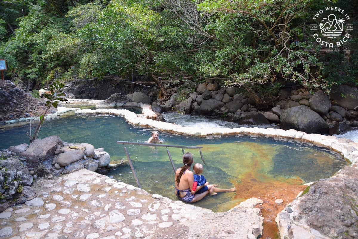 a family sitting in the hot springs at rio negro in costa rica