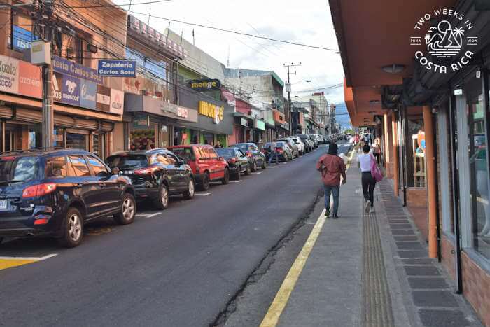 People on a paved city street and sidewalk in Heredia Costa Rica