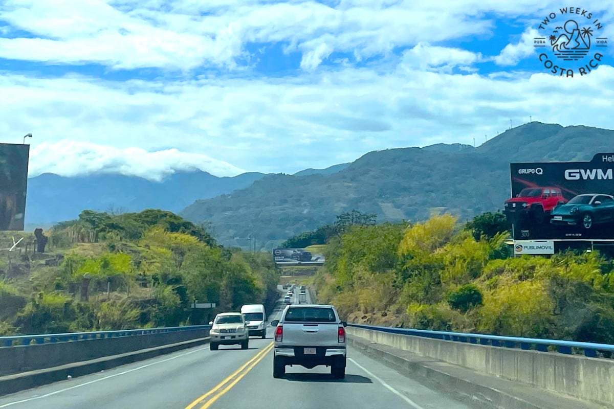 Highway in Costa Rica with mountains and clouds in the background