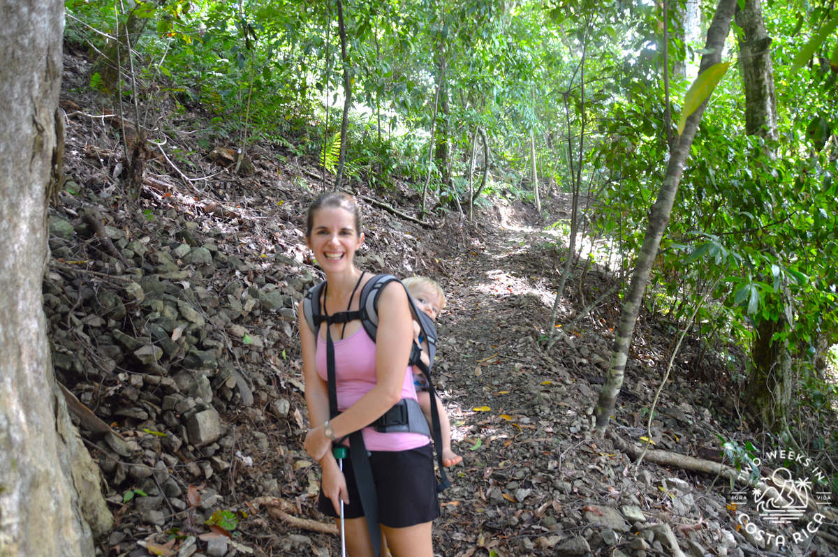 mom hiking through the forest with a baby in a carrier