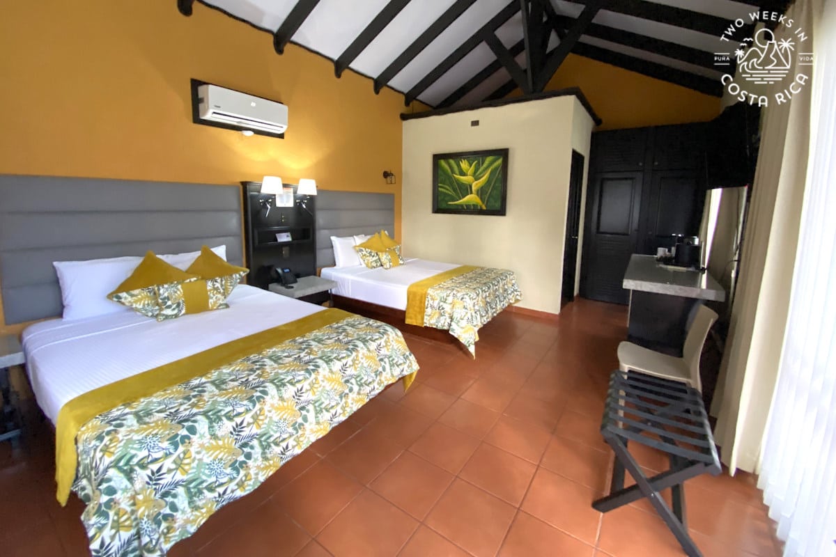 a hotel room with two beds and orange floors