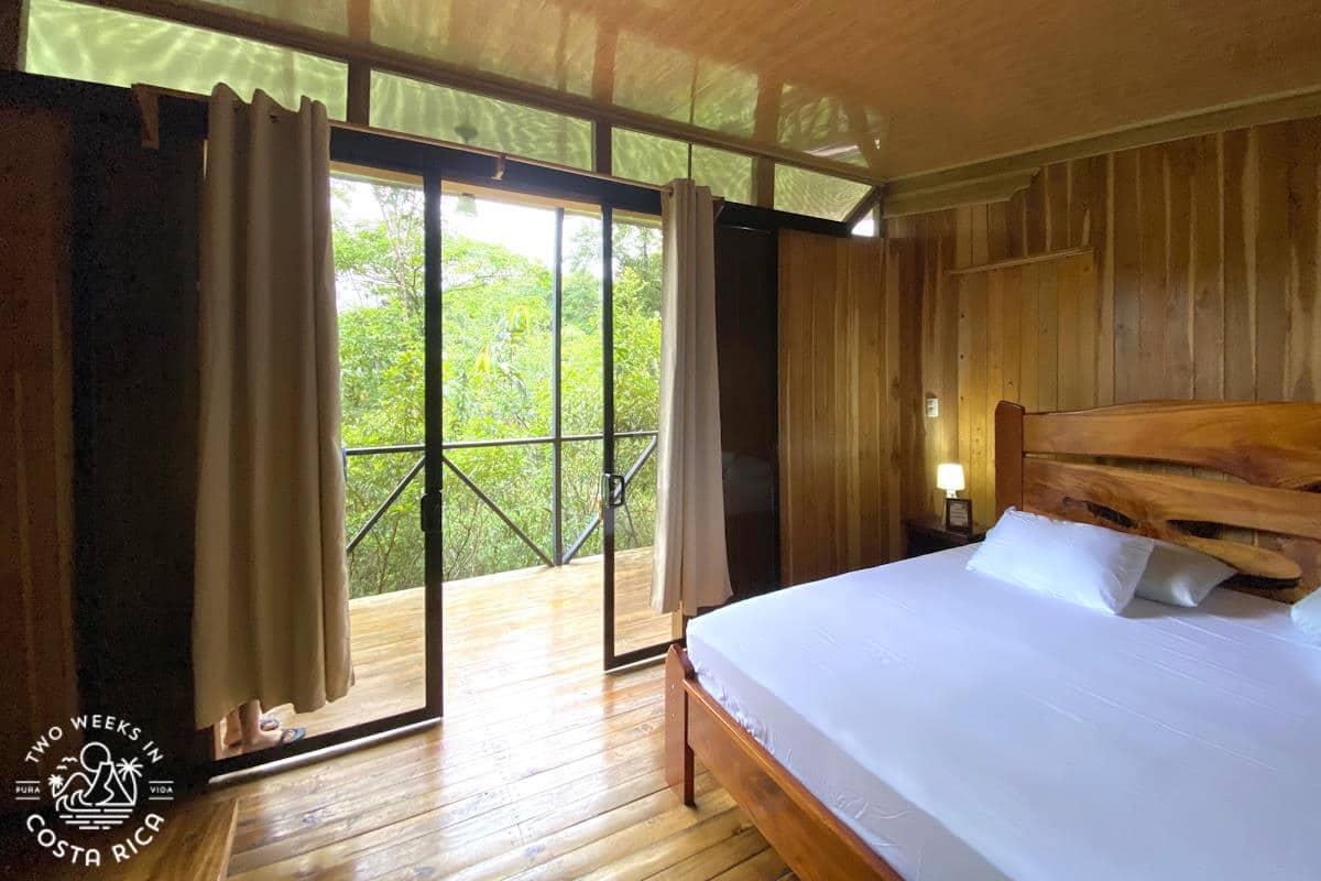 a wooden cabin with a bed overlooking the rainforest