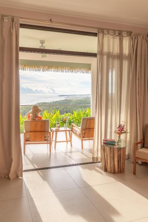 a woman sitting on a porch at lagarta lodge hotel