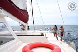 two people on a boat with an orange lifesaver in the foreground
