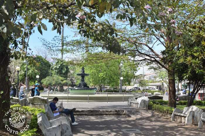 pathway to a large fountain with sitting benches in Heredia