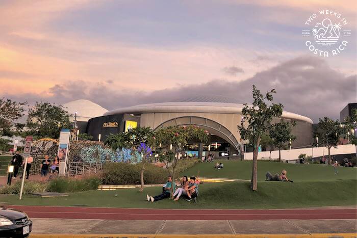 Large mall with dome roof and green space outside 
