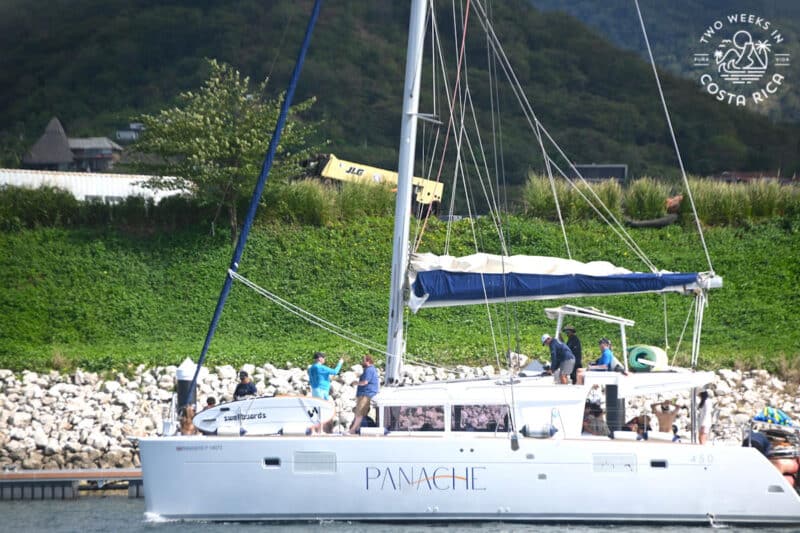 close up of catamaran sailboat with people on it