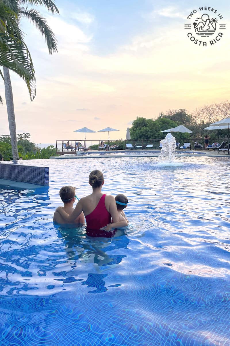 a mom with her kids in a pool at sunset