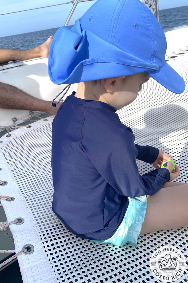 a small child sitting on a trampoline on a boat in costa rica