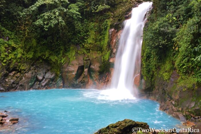 blue waterfall with lush rainforest