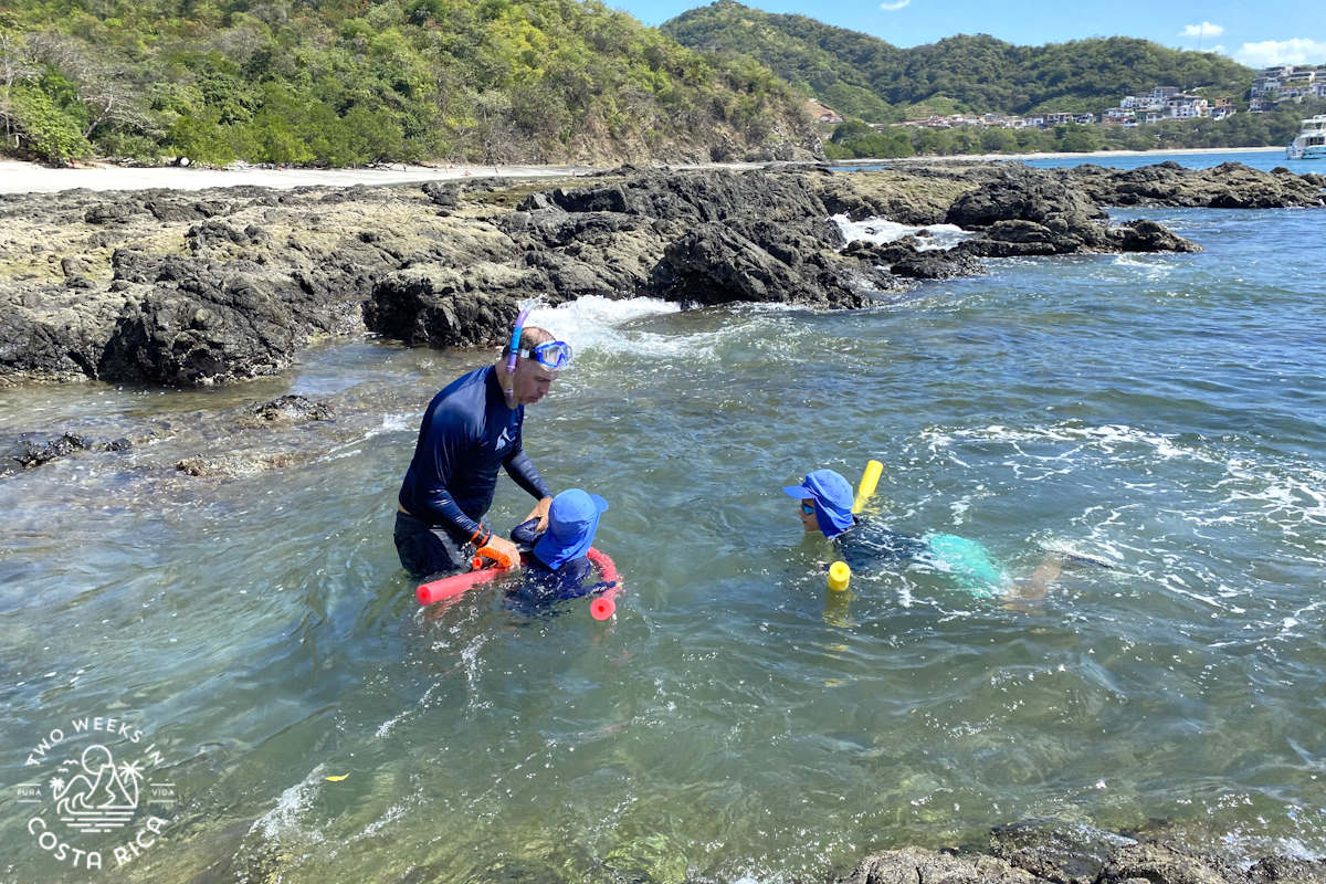 a family snorkeling along the rocks at playa dantita