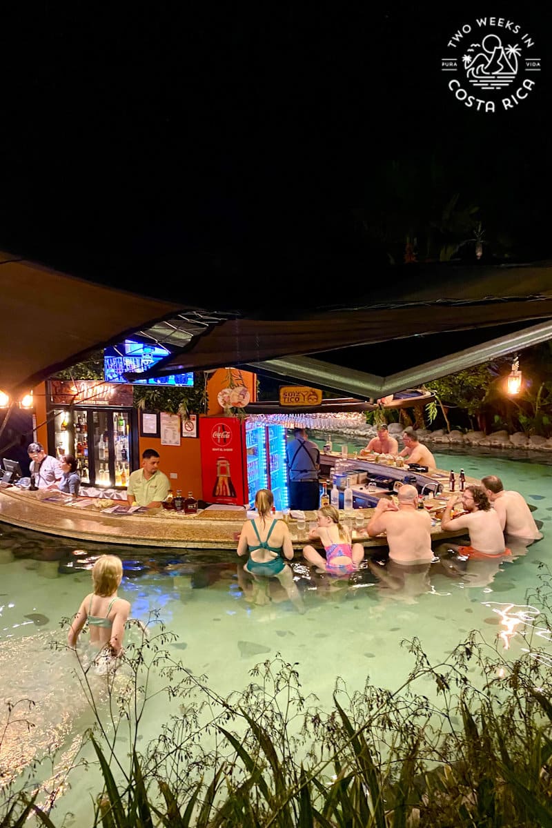 people sitting at a poolside bar at night
