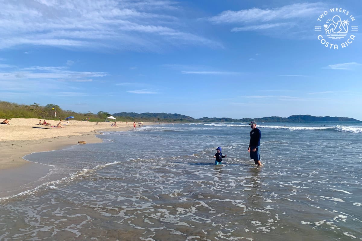 a family wading in the shallow water in nosara costa rica