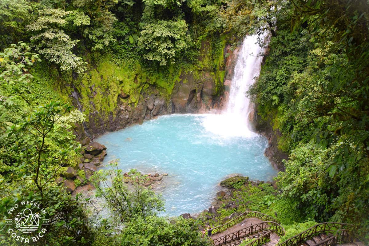 view from above of waterfall with blue pool