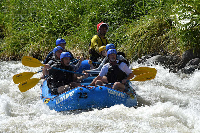 Large rubber raft traveling through whitewater in a jungle setting