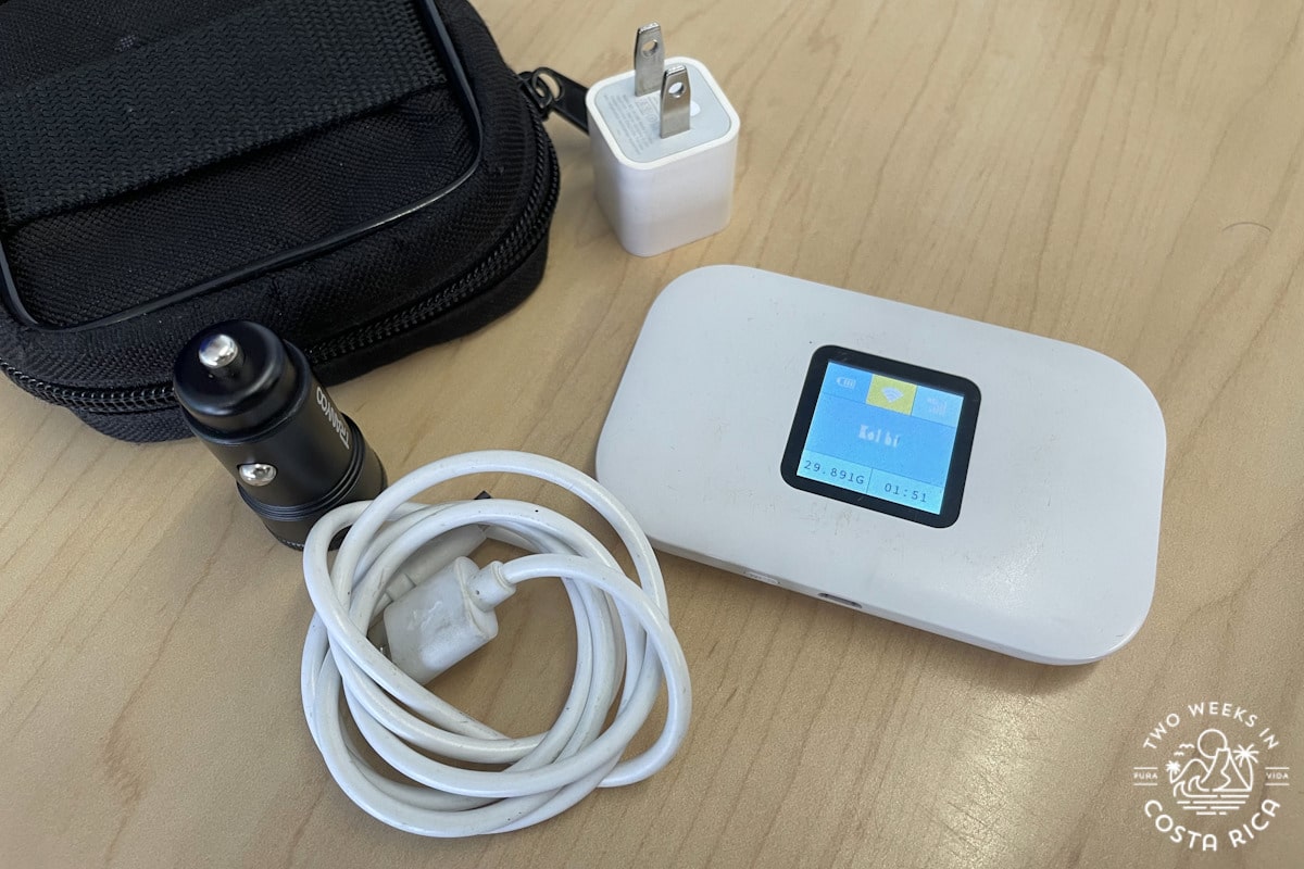 Small Wi-Fi device with charger and carrying case on a table